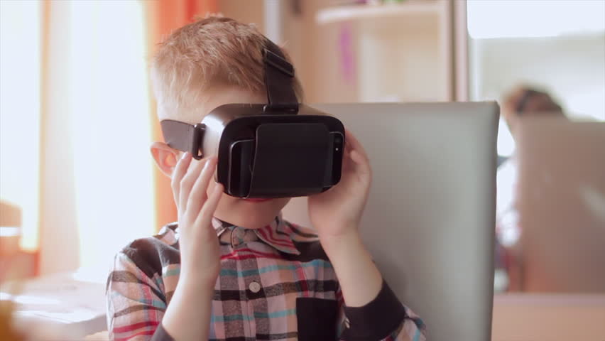 Little boy use virtual reality headset helmet, he very impressed