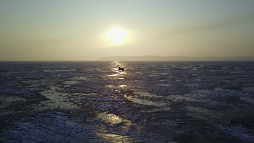 Sunrise. Motorcycle on ice-covered river. landscape
