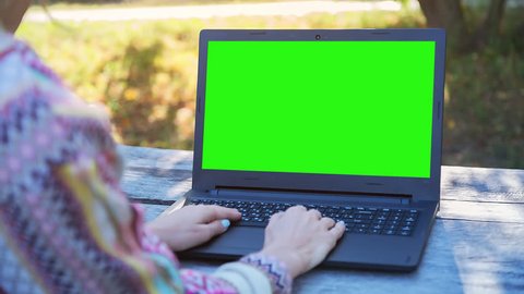 High quality 10bit footage of Beautiful Woman Using NoteBook with Pre Keyed Green Screen Sitting on the Bench in City.  Woman surfing web, social networks, looking something in online shop. ProRes 444