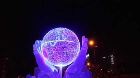 PERM, RUSSIA - JAN 10, 2017: Globe in hands with illumination at evening, Ice town of Perm in 2017 Ekosad - largest in Russia
