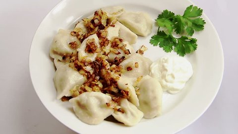 Russian national ravioli with onion on a plate rotation, on white plate and  white background