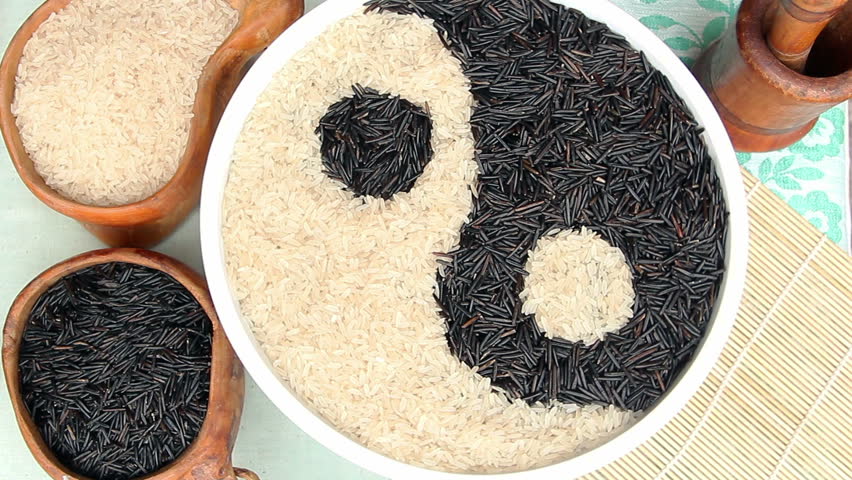 Bowls of black and white uncooked rice  forming a yin yang symbol 