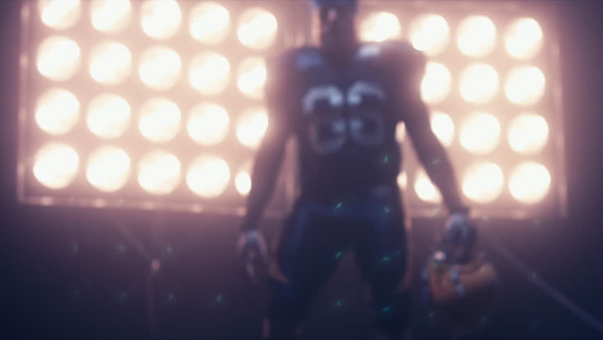 Silhouette of male American football player walking towards camera against bright stadium illumination lights. Bearded man. 4K UHD RAW edited footage Royalty-Free Stock Footage #24525797