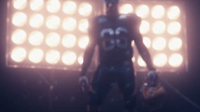 Silhouette of male American football player walking towards camera against bright stadium illumination lights. Bearded man. 4K UHD RAW edited footage
