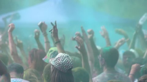 Youth crowd in a colorful summer disco concert. People crowd in colorful holi concert