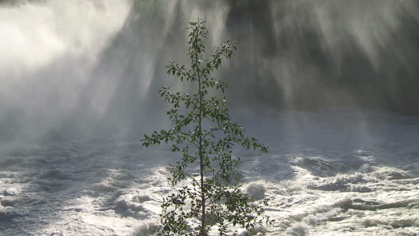 Water spray and mist rising from a large waterfall