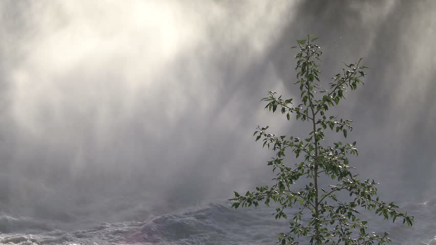 Water spray and mist rising from a large waterfall