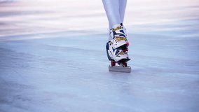 Speed ice skater skating on outdoor race HD video slow-motion. Close-up of professional athlete ice skates slides boots on legs foots.