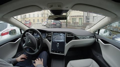 LJUBLJANA, SLOVENIA - FEBRUARY 4, 2017: Fully autonomous self-driving autopilot Tesla Model S driverless car entering a park seek mode and self-parking into space with no action required by the person