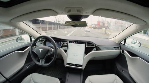 AUTONOMOUS TESLA CAR, FEBRUARY 2017: Fully autonomous self-driving autopilot Tesla Model S driverless car maneuvering on local street in urban city. Enhanced next gen intelligent robotic vehicle