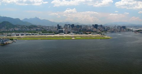 Aerial wide angle shot above ocean with airport and skyline of Rio de Janeiro, Brazil