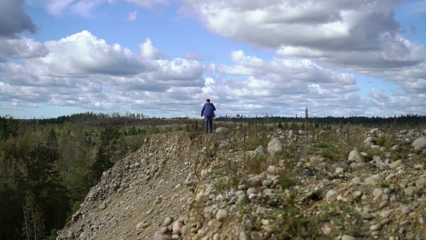 Young man walking on a rocks at summer
