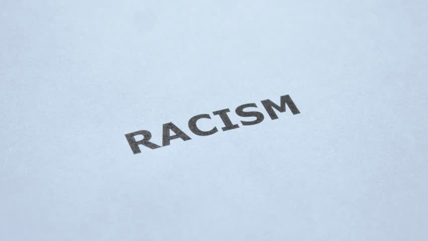 Stop Racism. Man hand crosses out the word Racism with black marker. No Racism