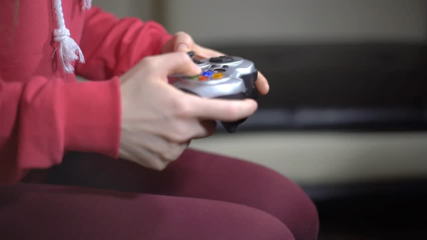Young Woman Playing Video Game Using A Gamepad