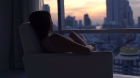Happy woman relaxing on armchair and admire view during sunset, super slow motion 240fps
