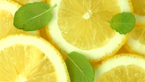 Lemon slices with mint leaf rotation background. Close-up of a delicious ripe lemon rotate and aromatic mint. Healthy food, cooking ingredient. UHD video footage. Ultra high definition 3840X2160 