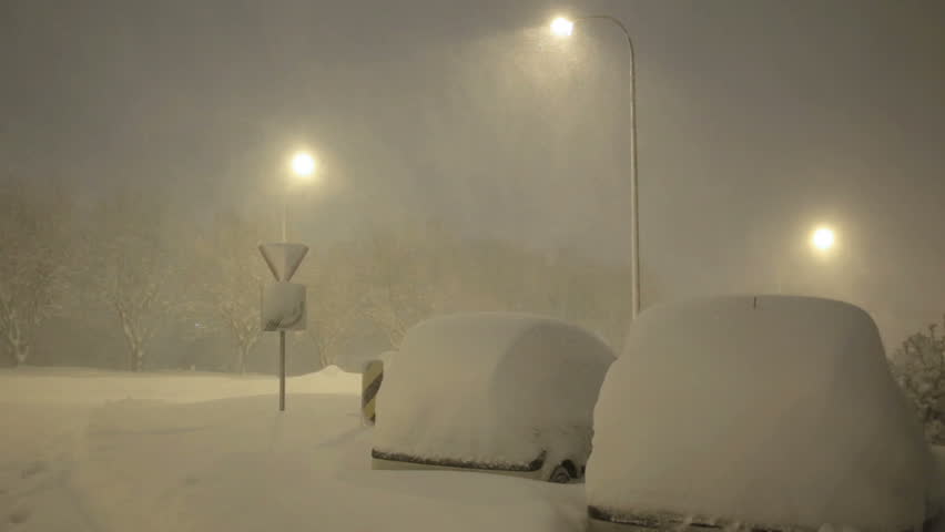 Cars under street lamps covered in deep snow winter blizzard Reykjavik Iceland