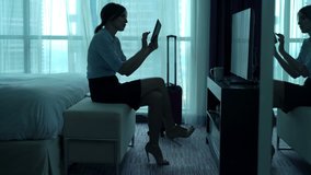 Happy businesswoman watching movie on tablet computer in hotel room
