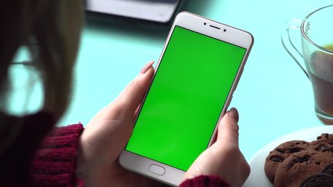 Beautiful girl holding a smartphone in the hands of a green screen green screen, hand of man holding mobile smart phone with chroma key green screen on white background, new technology concept