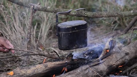 Cooking with cauldron on campfire.