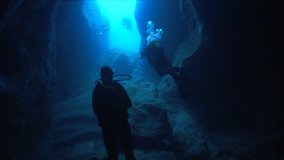 scuba divers exploring cave underwater cave dive