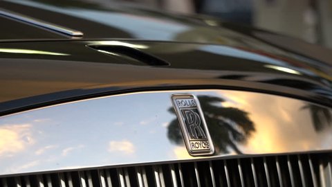 MIAMI, FLORIDA - FEBRUARY 2017: Front of Rolls Royce Ghost Luxury Car with Tropical Palm Trees 