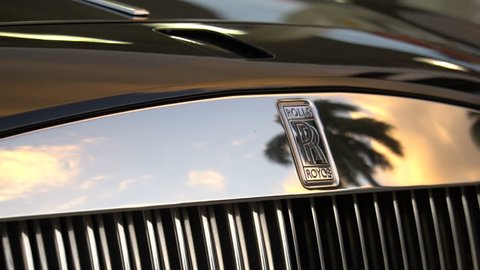 MIAMI, FLORIDA - FEBRUARY 2017: Front of Rolls Royce Ghost Luxury Car with Tropical Palm Trees 