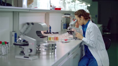 Woman scientist start working with microscope. Microbiologist looking microscope. Microbiology laboratory research. Female scientist looking through microscope in lab. Scientist microscope