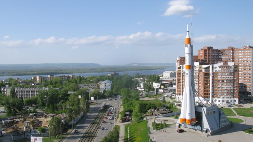 Monument rocket stands at mountain top against city landscape of Samara, time lapse
