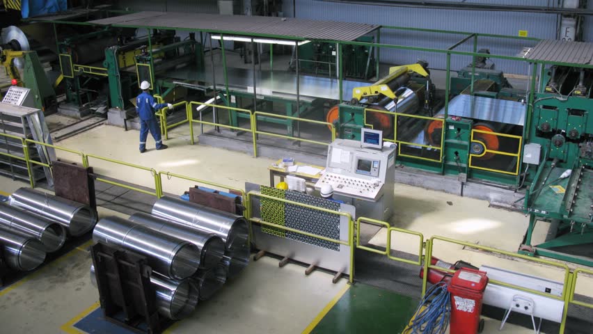 Roll of aluminum rotates on machine in workshop on plant, time lapse