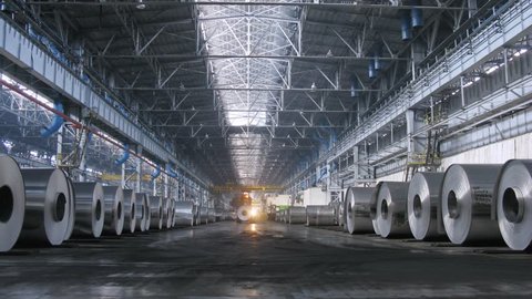 Loader distributes aluminum rolls in shop on rolling mill, time lapse