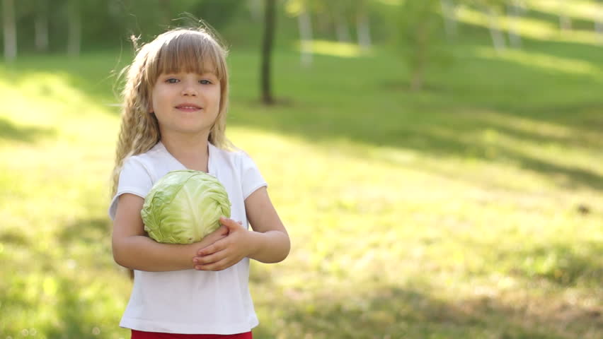 Child holding a cabbage. Thumbs up. Ok.
