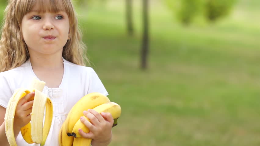 Child eating bananas outdoor
