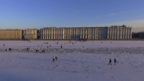 Aerial view of People walk on frozen the Neva River in Saint Petersburg in weekend, sunny frosty day, Peter and Paul Fortress, Winter Palace, Hermitage, Admiralty, Palace Bridge, Rostral columns