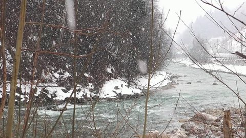 River flows in winter - Snow falls