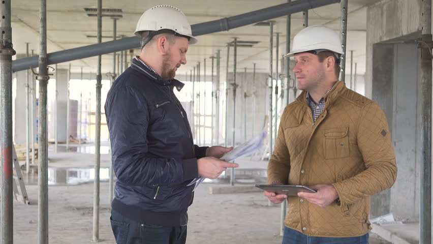 Two engineers discussing about building work and shake hands. Royalty-Free Stock Footage #24625541