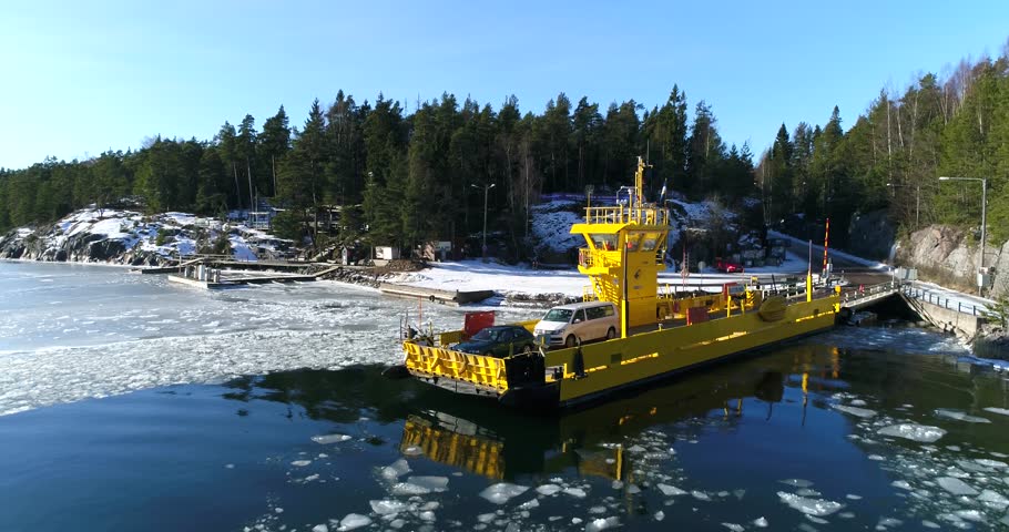 Cinema 4k aerial rising view of a cable ferry, docking in the main land at Barosund or Baronsalmi of the finnish archipelago, of Inkoo, Finland.