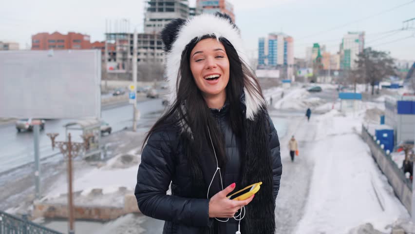 beautiful curly long brunette hair moroccan woman using smart phone in the city