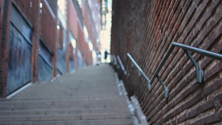 People walking staircase in city. Selective focus handrail