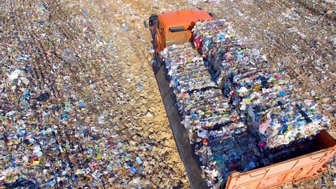 Truck unloading garbage, waste at landfill, junkyard. Aerial view.