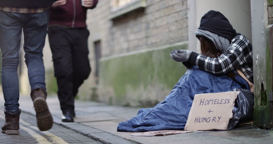 4k, A kind hearted young man offering a cup of coffee to a homeless person sitting outside in cold. Slow motion Royalty-Free Stock Footage #24648503