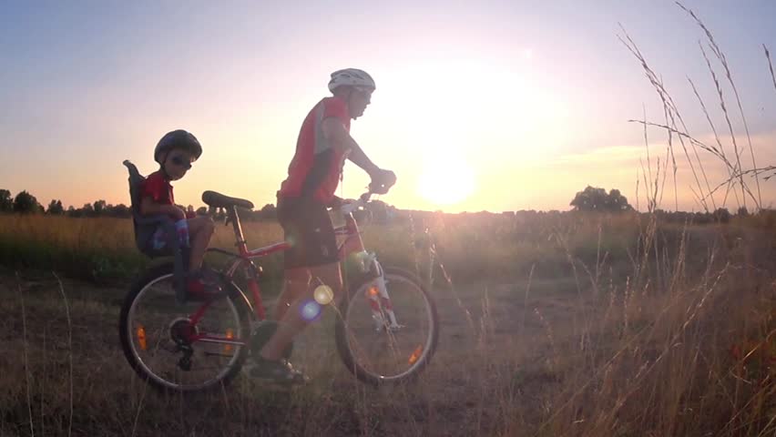 Father and son ride a bike at sunset slow motion | Shutterstock HD Video #24649391