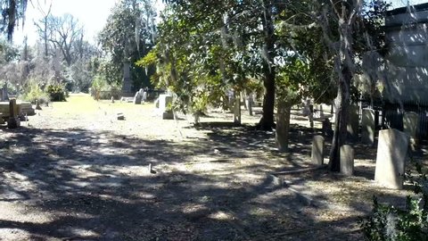 SAVANNAH, GEORGIA, USA - FEBRUARY 25, 2017: Pan shot in an historic old cemetery in Savannah, Georgia, USA.  It is daytime, with a slight breeze blowing.