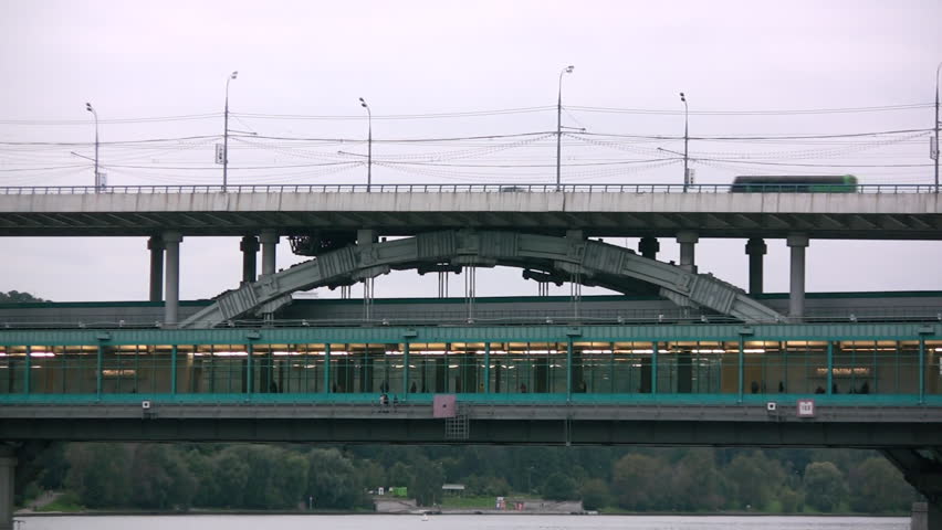 A traffic of cars and trains on a bridge