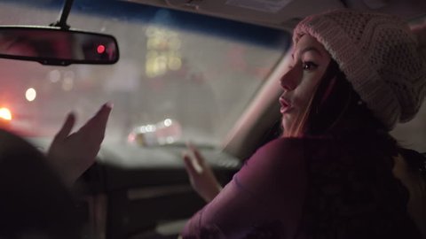 Driver And Passenger Sing And Dance To Music In Moving Car In City At Night