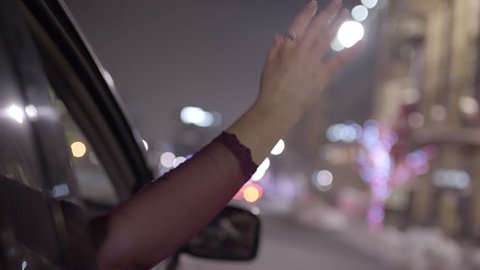Young Woman Puts Her Hand Out Moving Car Window, Feels The Breeze At Night In City