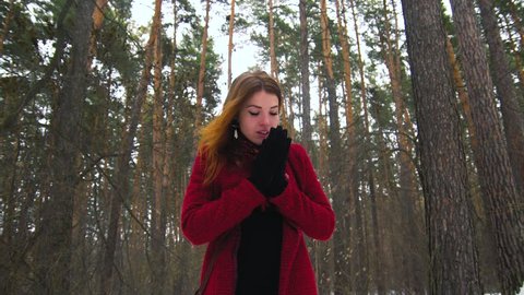 Young red hair woman enjoying snowfall outdoors, smiling and laugh looking at camera in slow motion 120fps