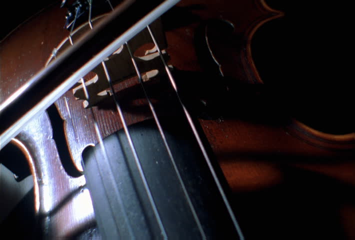 Close-up of bow moving across violin, no violinist shown | Shutterstock HD Video #24688373