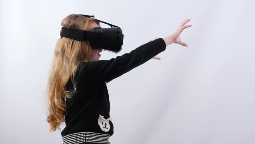 Girl uses virtual reality glasses to play game. 