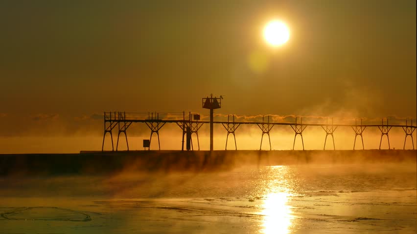 Cold steaming Lake Michigan at Sunrise with iconic Algoma Wisconsin Lighthouse.